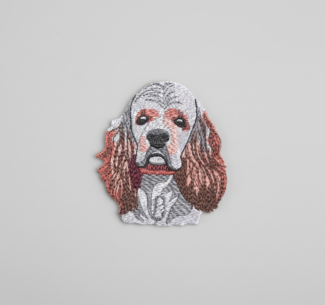 Embroidered design of a American Cocker Spaniel dog's face on a grid background
