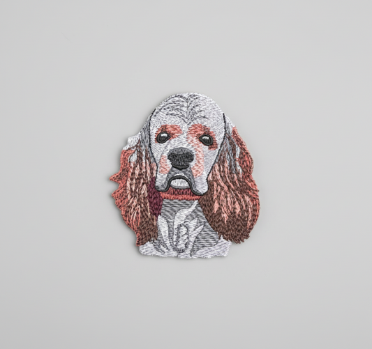 Embroidered design of a American Cocker Spaniel dog's face on a grid background
