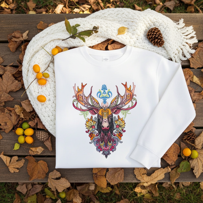 White sweatshirt featuring a colorful baroque moose head embroidery-style design with ornate antlers, styled on a wooden bench with a cozy knit scarf, berries, pinecones, and autumn leaves.