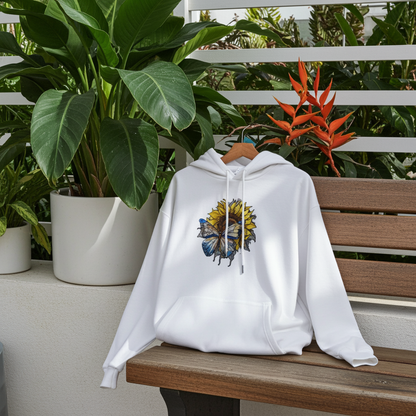 White hoodie mockup featuring an embroidered blue butterfly and sunflower design on the chest, styled on a bench outdoors with lush green plants.
