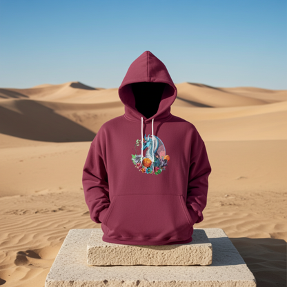 Burgundy hoodie mockup featuring an embroidered blue dragon surrounded by flowers on the chest, displayed outdoors on a stone block in a desert dune landscape.