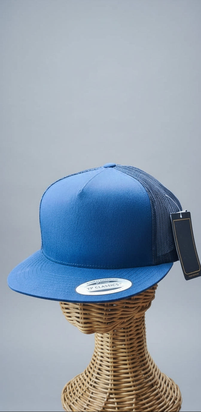 Blue cap with a logo on a mannequin head against a blurred indoor background