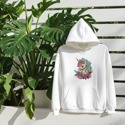 White hoodie mockup featuring an embroidered floral unicorn design on the chest, styled outdoors on a terrace with large green plants and a white fence backdrop.