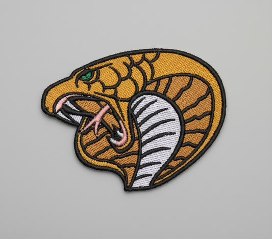 Embroidered patch of a snake's head on a grid background