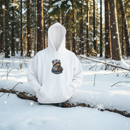 White hoodie mockup featuring an embroidered bear in a knit hat and scarf holding a warm drink, shown outdoors in a snowy forest with falling snow.