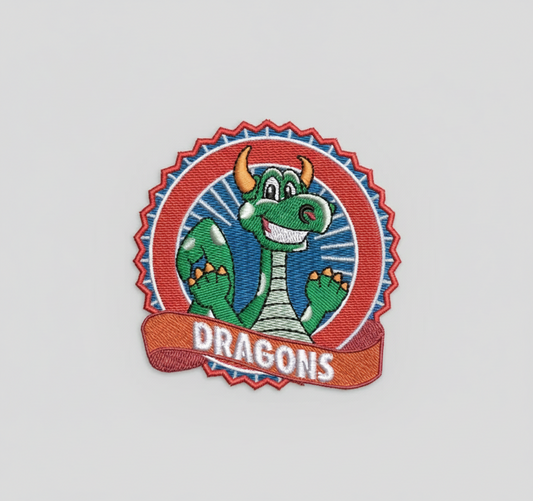 Embroidered patch with a cartoon dragon and 'DRAGONS' text on a grid background