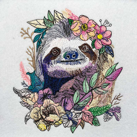 Embroidered design of a sloth surrounded by flowers and leaves on a white background