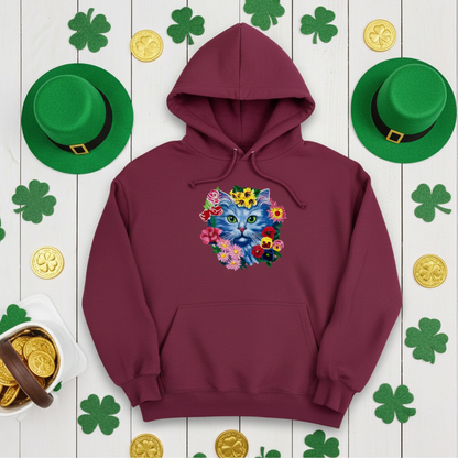 Burgundy hoodie mockup featuring an embroidered blue cat face surrounded by colorful flowers on the chest, styled with shamrock decorations, green hats, and gold coins on a white background.