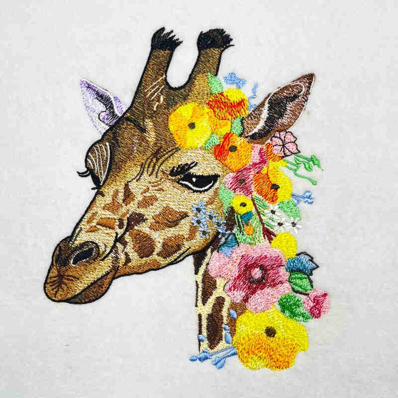 Embroidered jute tote bag featuring a giraffe with floral accents.
