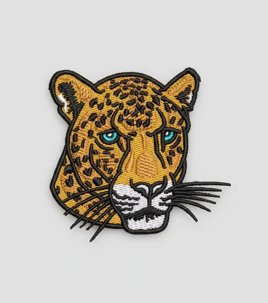 Embroidered patch of a leopard's face on a grid background