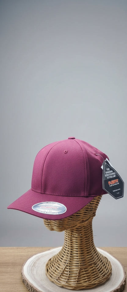 Pink cap on a mannequin head with a brand tag in an indoor setting