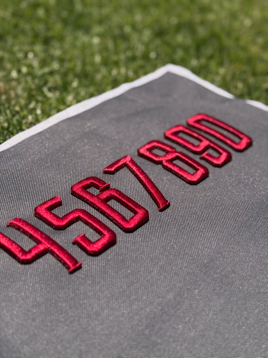 Gray towel with red numbers on grass