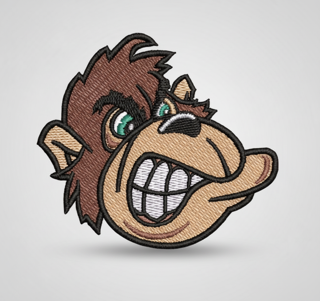 Embroidered patch of a cartoonish Monkey head with a grid background