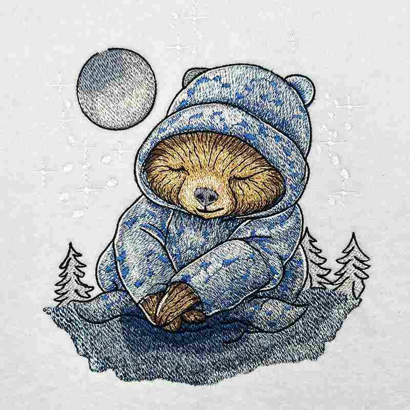 Embroidered illustration of a sleepy sloth in a blue winter hoodie sitting under a full moon with small pine trees, cozy winter night theme, original EmbroMania design.