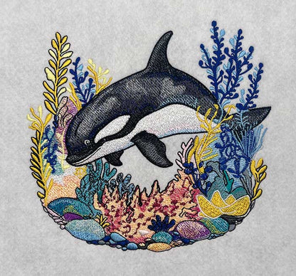 Embroidered design featuring a majestic orca whale surrounded by colorful marine life and waves.