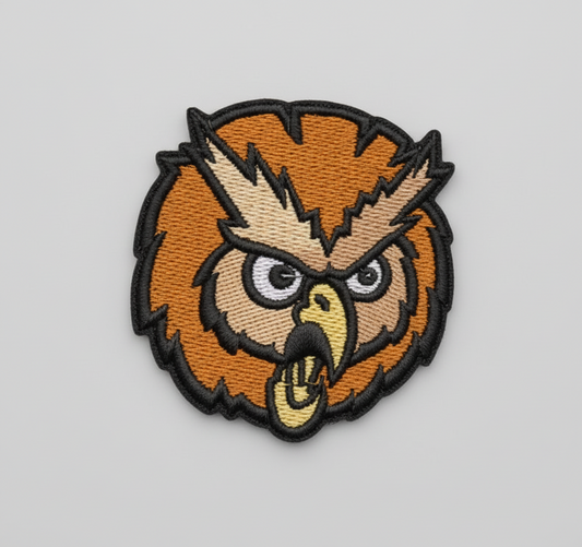 Embroidered owl patch on a grid background