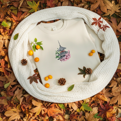 Mint green unisex crewneck sweatshirt with pagoda and sakura cherry blossom embroidery design, flat lay with cozy scarf, autumn leaves and berries.