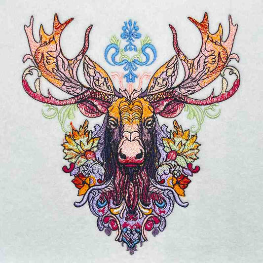 Embroidered moose head with large ornate antlers and tribal-inspired decorative patterns in warm orange, red, purple, and blue tones, original EmbroMania design.