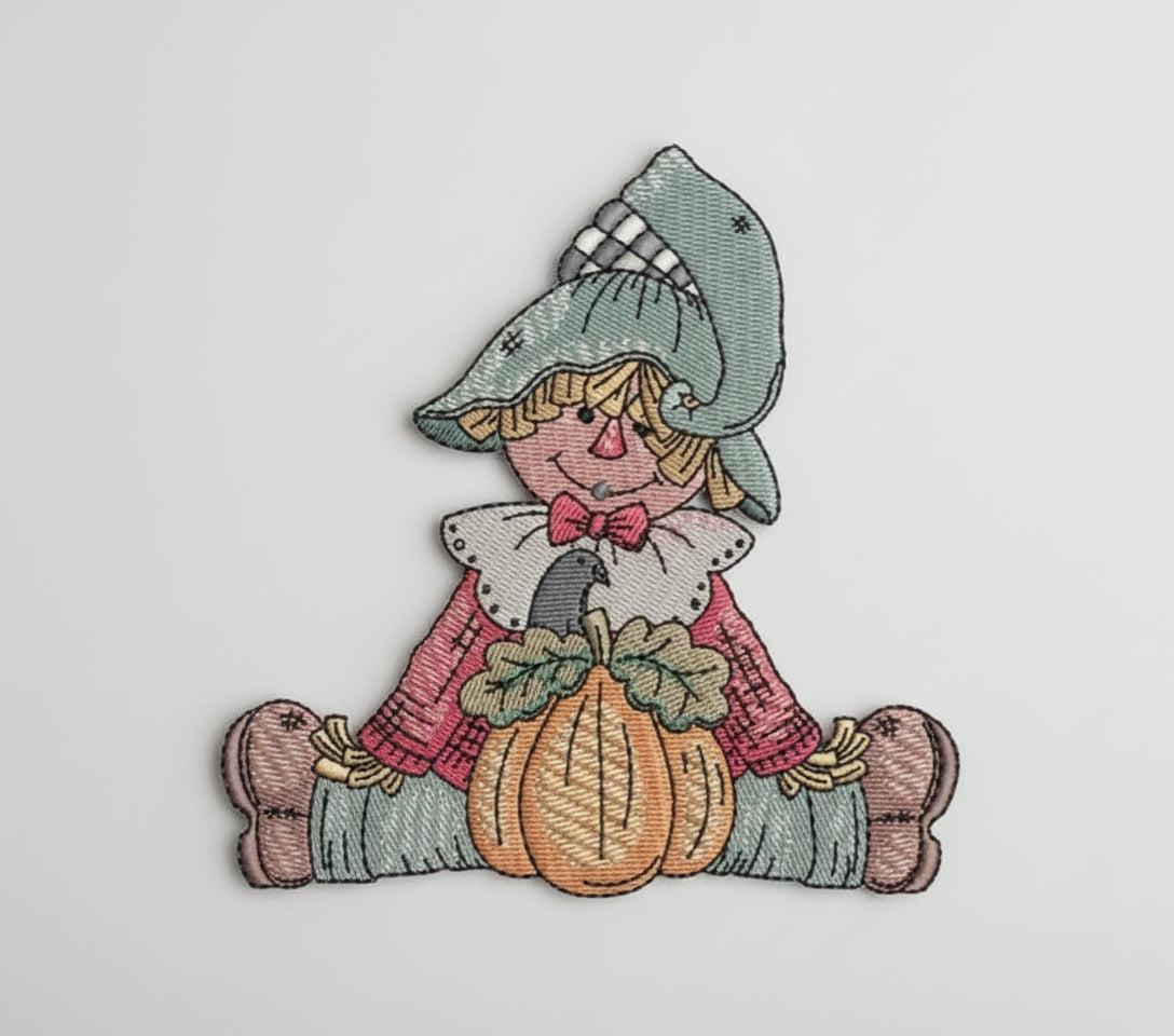 Embroidered design of a scarecrow holding a pumpkin on a white background