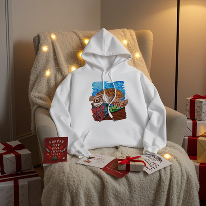 White premium hoodie with Sea Turtle & Coral Reef embroidery showing a sea turtle above red coral and green sea plants on a blue ocean background, styled on a cozy chair with string lights, holiday cards, and wrapped gifts, original EmbroMania artwork.