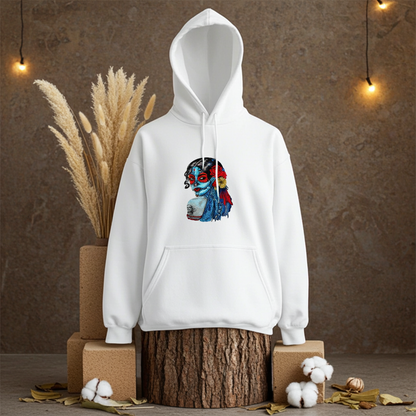 White premium hoodie with Sugar Skull Lady embroidery featuring a Día de los Muertos portrait in blue and red tones with floral accents, displayed on a wooden stump with dried pampas grass and cotton in a warm studio, original EmbroMania artwork.