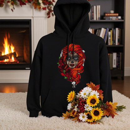 Black premium hoodie with Sugar Skull Rose Girl embroidery featuring a sugar skull portrait with bright orange hair and red roses, styled indoors by a fireplace with an autumn flower bouquet, original EmbroMania artwork.