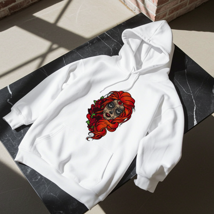White premium hoodie with Sugar Skull Rose Girl embroidery featuring a sugar skull portrait with bright orange hair and red roses, laid flat on a black marble surface in natural light, original EmbroMania artwork.