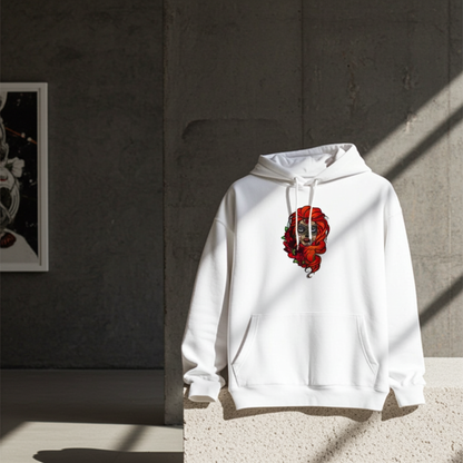 White premium hoodie with Sugar Skull Rose Queen embroidery featuring a sugar skull portrait with bright orange hair and red roses, styled against a minimalist gray wall in dramatic natural light, original EmbroMania artwork.