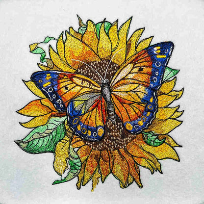 Butterfly on a sunflower with embroidered details on white fabric