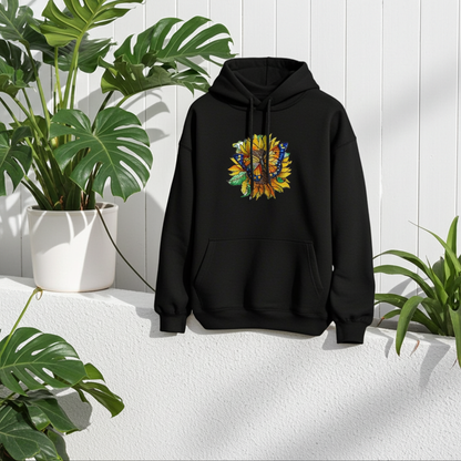 Black premium hoodie with Sun-Kissed Butterfly & Sunflower embroidery featuring a blue and orange butterfly on a golden sunflower with green leaves, hanging in a bright space with lush green plants and a white wall, original EmbroMania artwork.