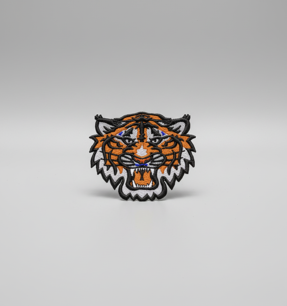 Embroidered tiger head design on a grid background