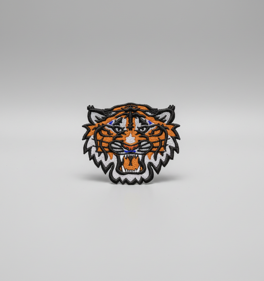 Embroidered tiger head design on a grid background