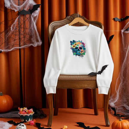 White sweatshirt hanging on a chair in a Halloween-themed room with fireplace and orange curtains, featuring a colorful floral blue skull embroidery on the chest, with pumpkins, bats, and spooky decor in the background.