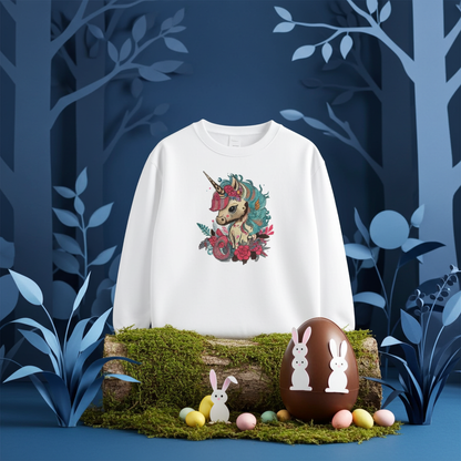 White unisex crewneck sweatshirt with whimsical unicorn and floral embroidery design, styled in enchanted forest scene with Easter egg and pastel candies.
