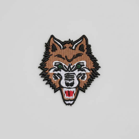 Embroidered patch of a wolf's head on a grid background