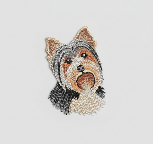 Embroidered design of a Yorkshire Terrier dog's face on a grid background