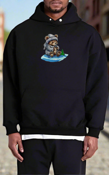 Person wearing a black hoodie with a teddy bear design on a blurred background