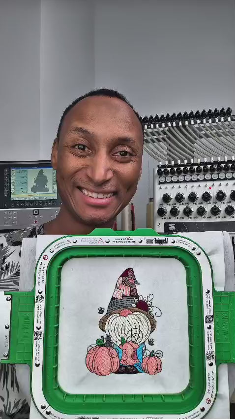 Embroidered fall design featuring a whimsical gnome with a sunflower hat, holding a pumpkin, surrounded by pumpkins and bees. Perfect for hoodies, sweatshirts, and tote bags.